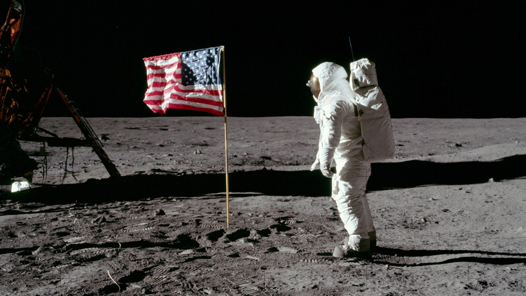 Astronauta en la luna frente a bandera norteamericana