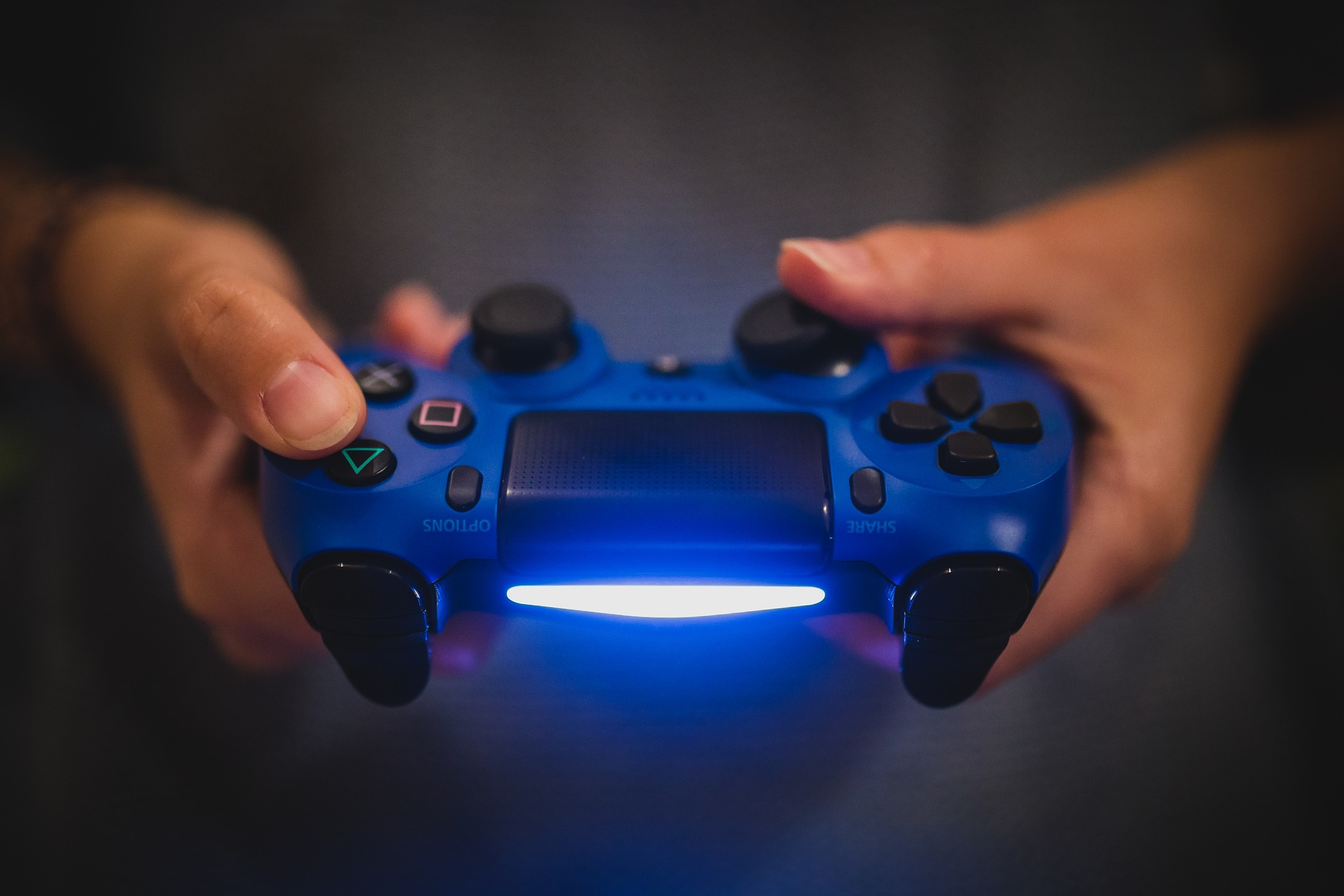 Un gamer juega con un control de PS4